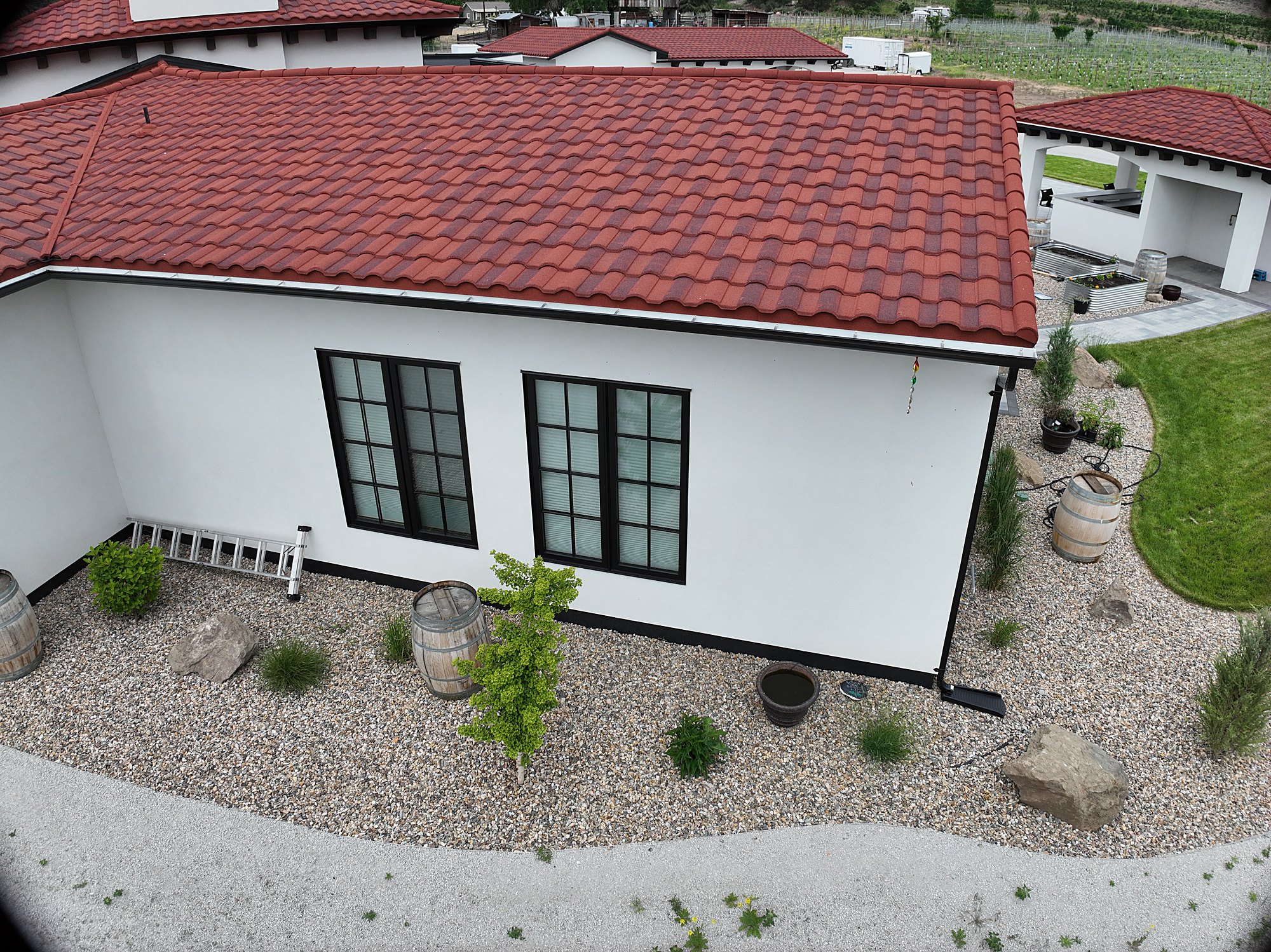 Low-oblique aerial of a red-roof estate's front facade and grounds, a demonstration capture.