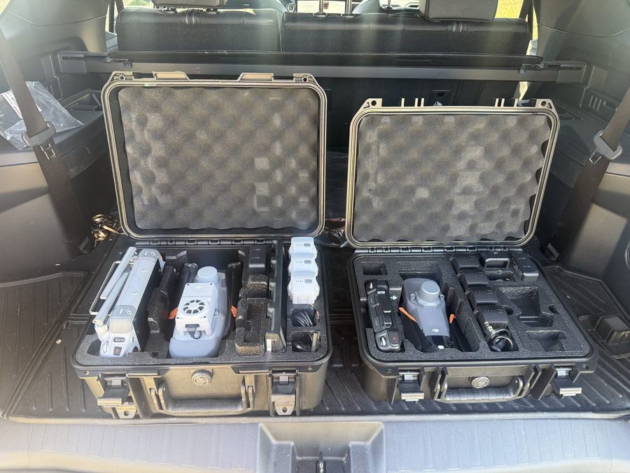 Two open equipment cases in a truck bed, packed for a morning flight.