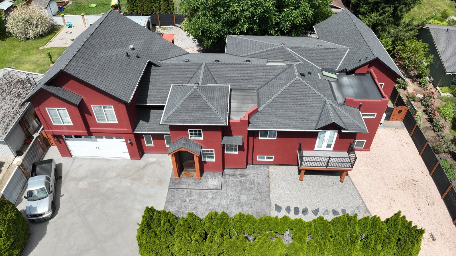 High aerial oblique of a building's full roof and envelope, every plane, ridge, valley and rooftop detail captured from the air, with no climbing or lift.