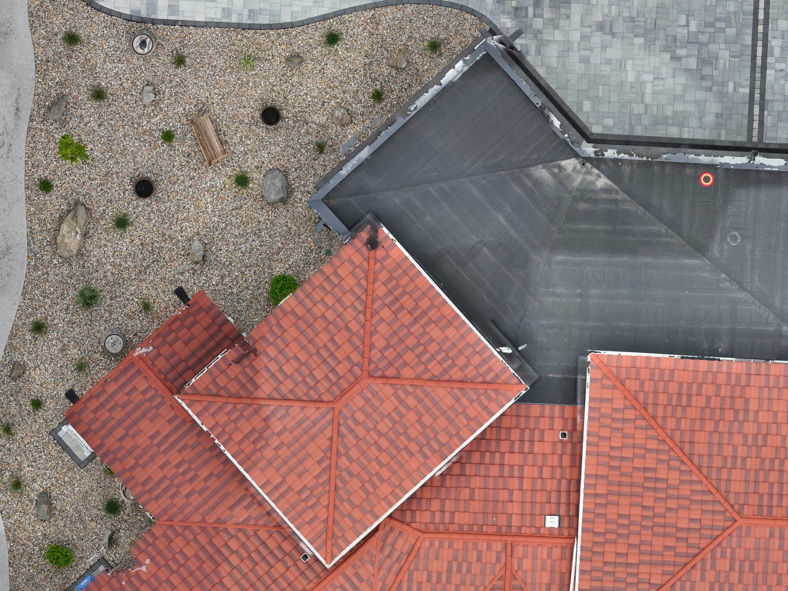 Top-down drone view of a tiled roof and surrounding grounds at tile-level detail. Activates a larger view.