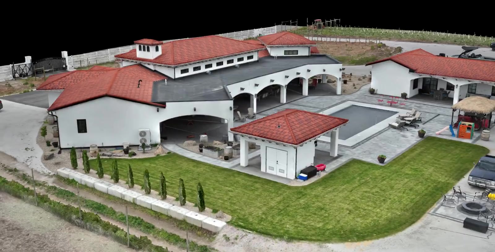 Still from the rendered Blair Street flythrough, showing the red-tile-roofed house and grounds with the vineyard hillside rising behind it, all reconstructed from the one capture.
