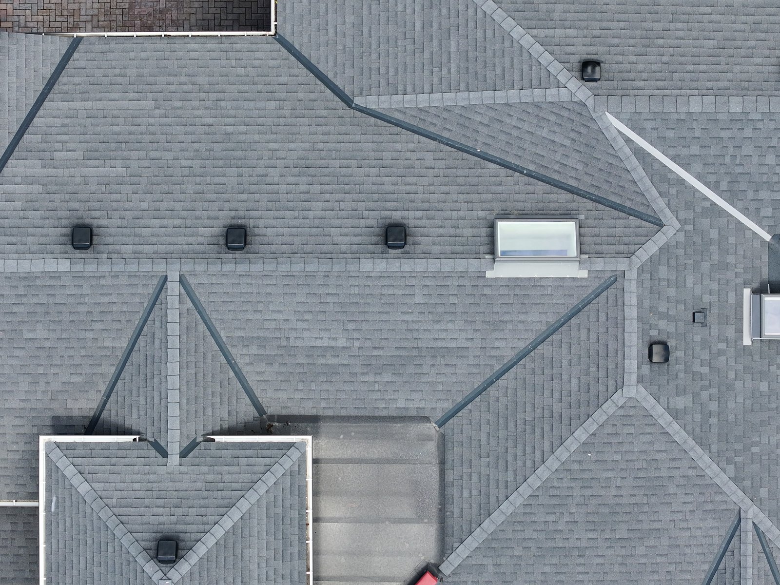 Drone cross-section view of the 1506 Johnston roof, slopes, valleys and ridge line visible end-on from a safe standoff.
