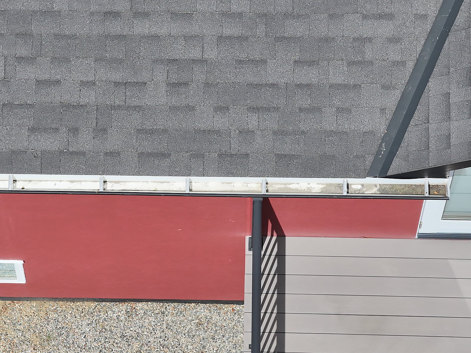 High-zoom drone detail of a roof edge and flashing line, captured from a safe standoff distance.
